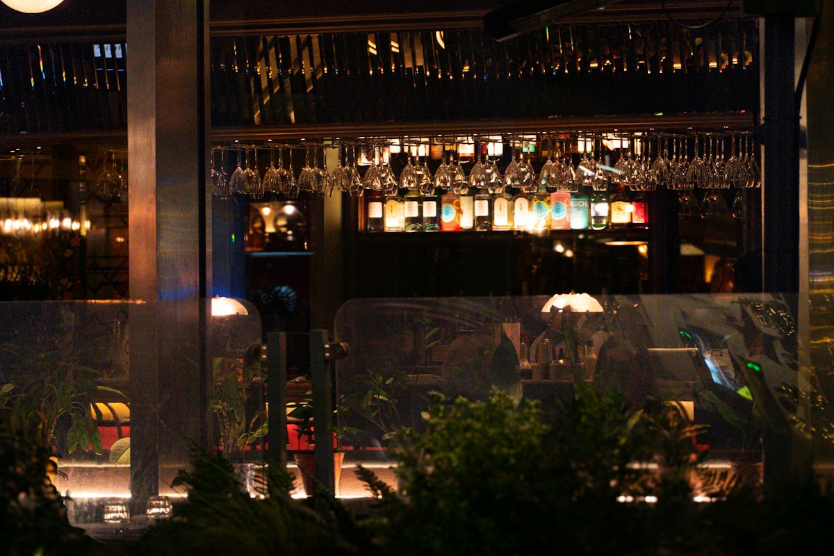 Warmly lit bar interior with hanging glasses (illustrative photo)